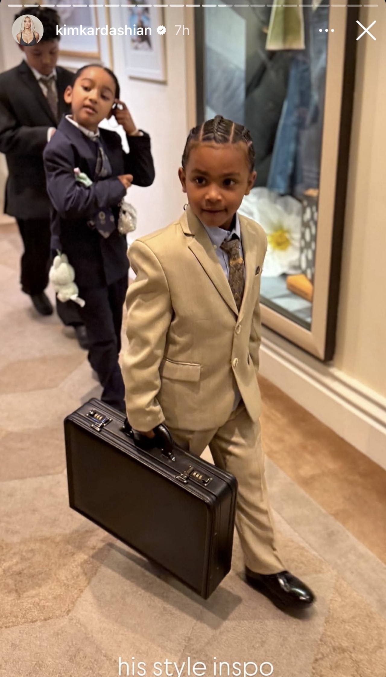 Psalm West is shown in a suit with a briefcase in photos from Kim Kardashian's Instagram Stories celebrating her graduation from lawschool.