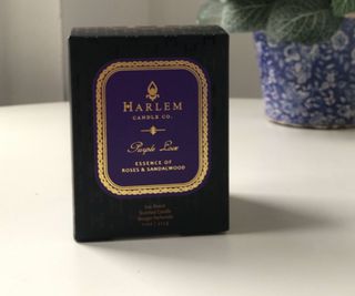 Harlem Candle Co Purple Love box on a white table with a plant in the background