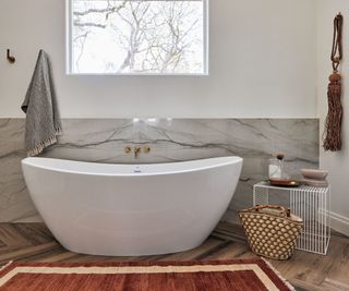 bathroom with high window and contemporary bathtub and burgundy bath mat