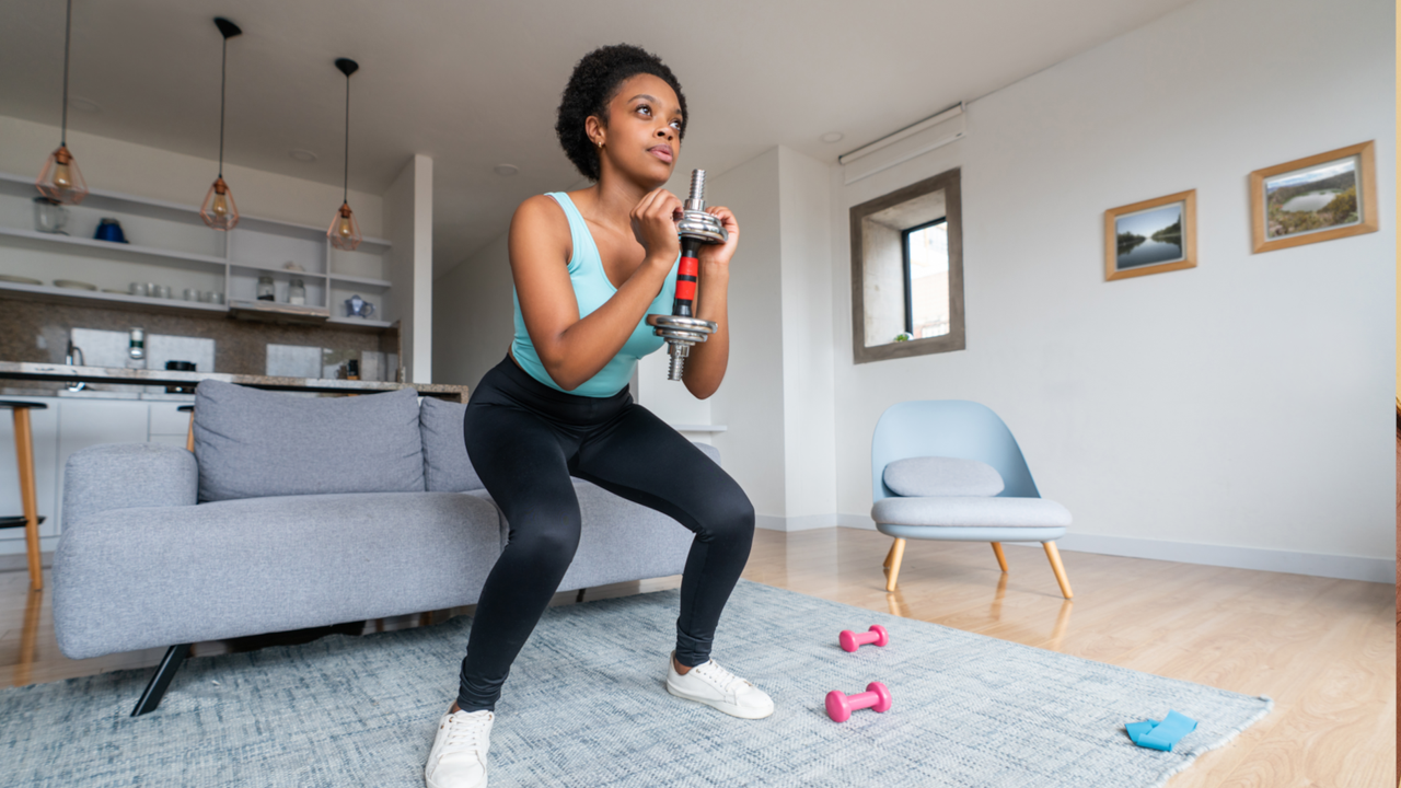 Woman squatting with dumbbell