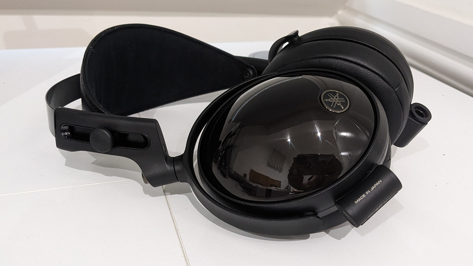 Yamaha YH-C3000 over-ear headphones on white surface with Yamaha logo visible on earcup