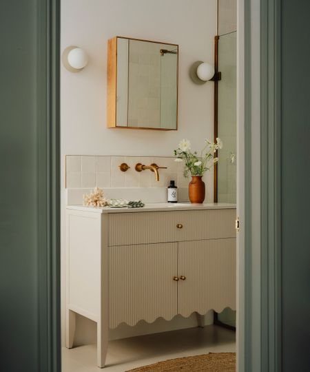 A small bathroom with a cream vanity unit