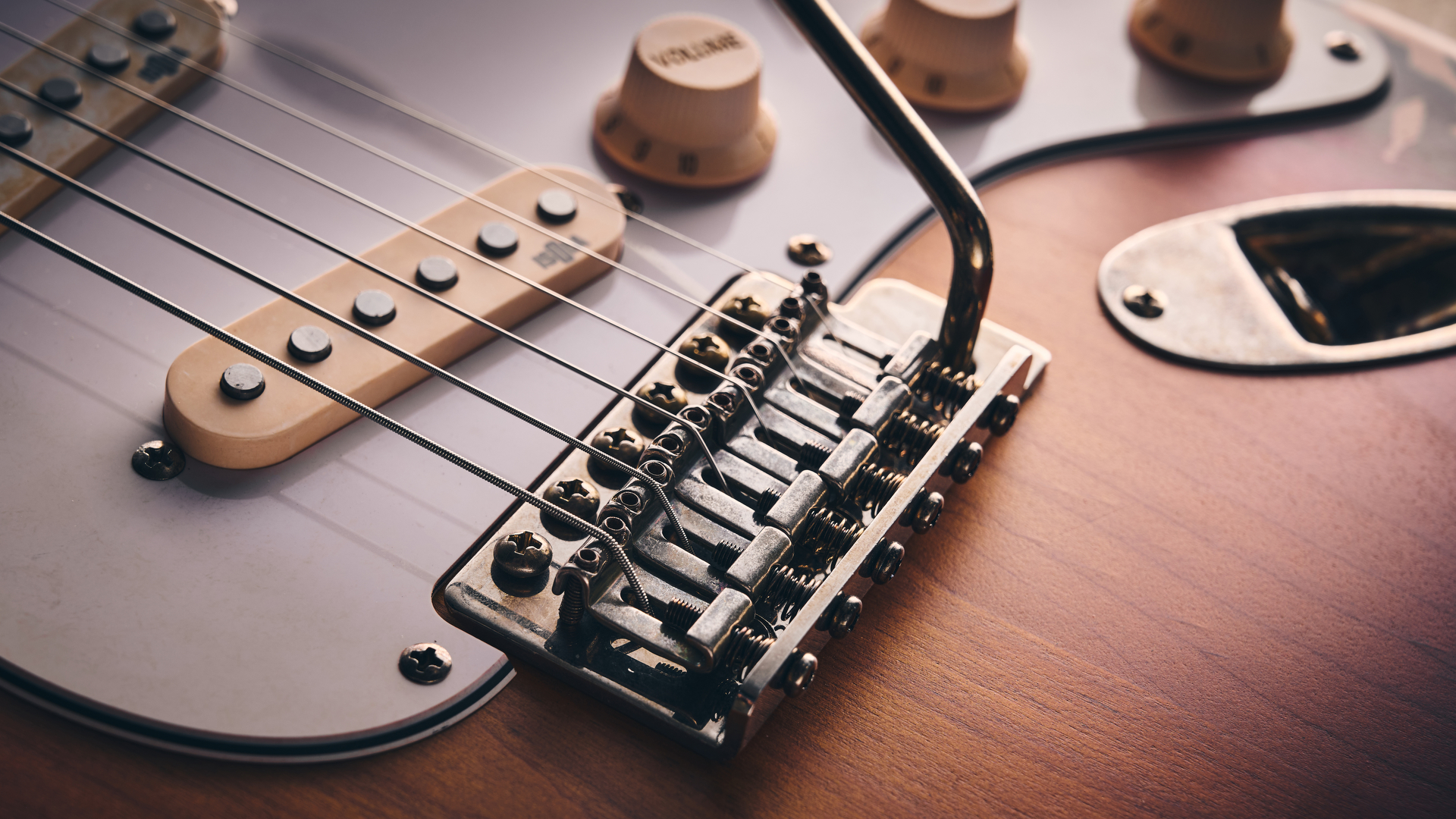 Close up of the tarnished bridge saddles on a Harley Benton ST-62HA electric guitar