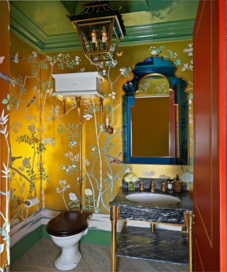 bathroom with gold leaf wallpaper, green ceiling and black marble washstand