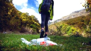 Careless climbers in mountain trashing water bottle on the grass