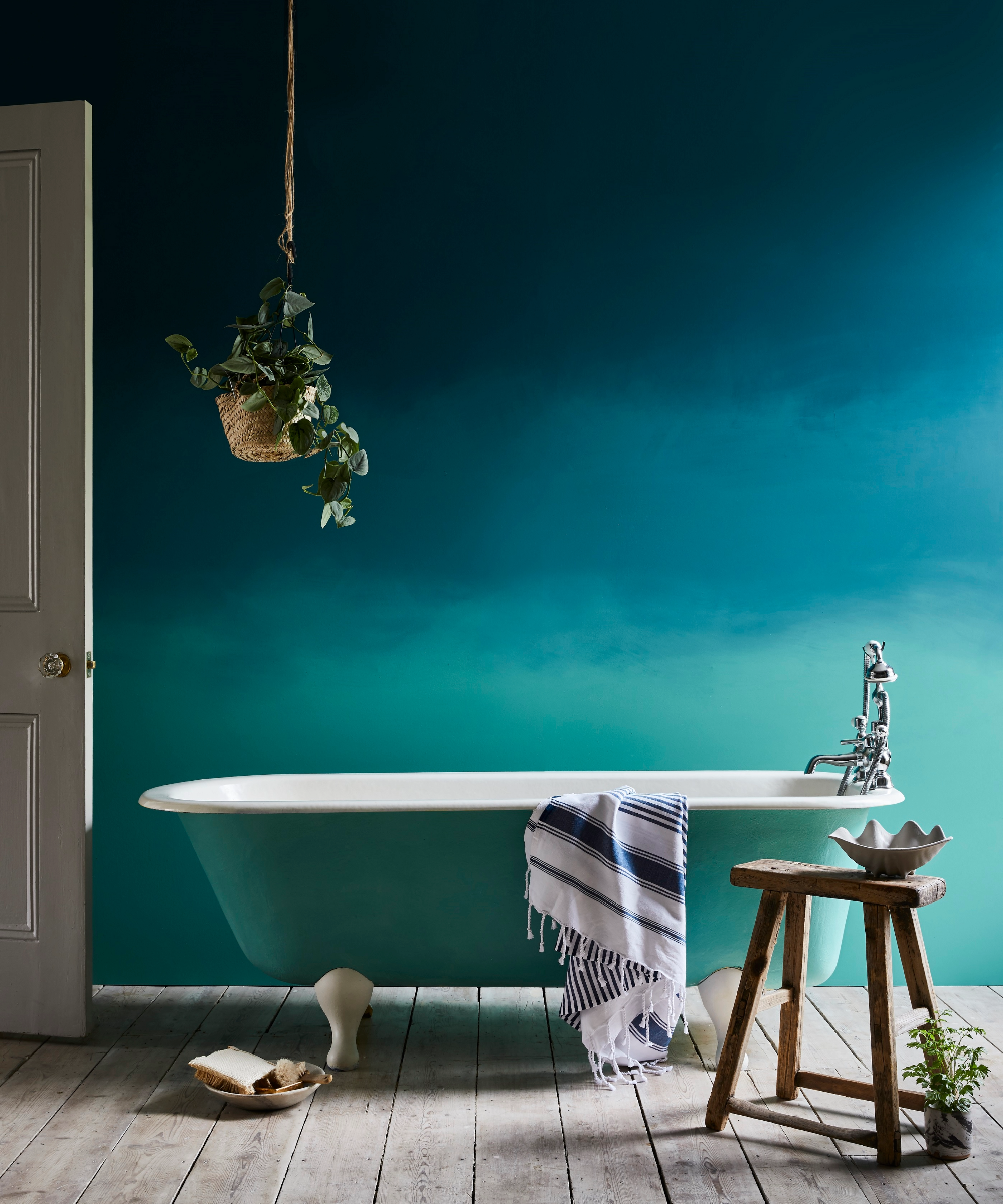 Blue bathroom idea with dark blue top wall fades into greeny blue that matches the bath