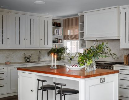 A white kitchen with big cabinets and an island