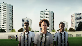 Three players pose at Henri Vidal Stadium against a backdrop of high-rises in Now or Never: FC Montfermeil