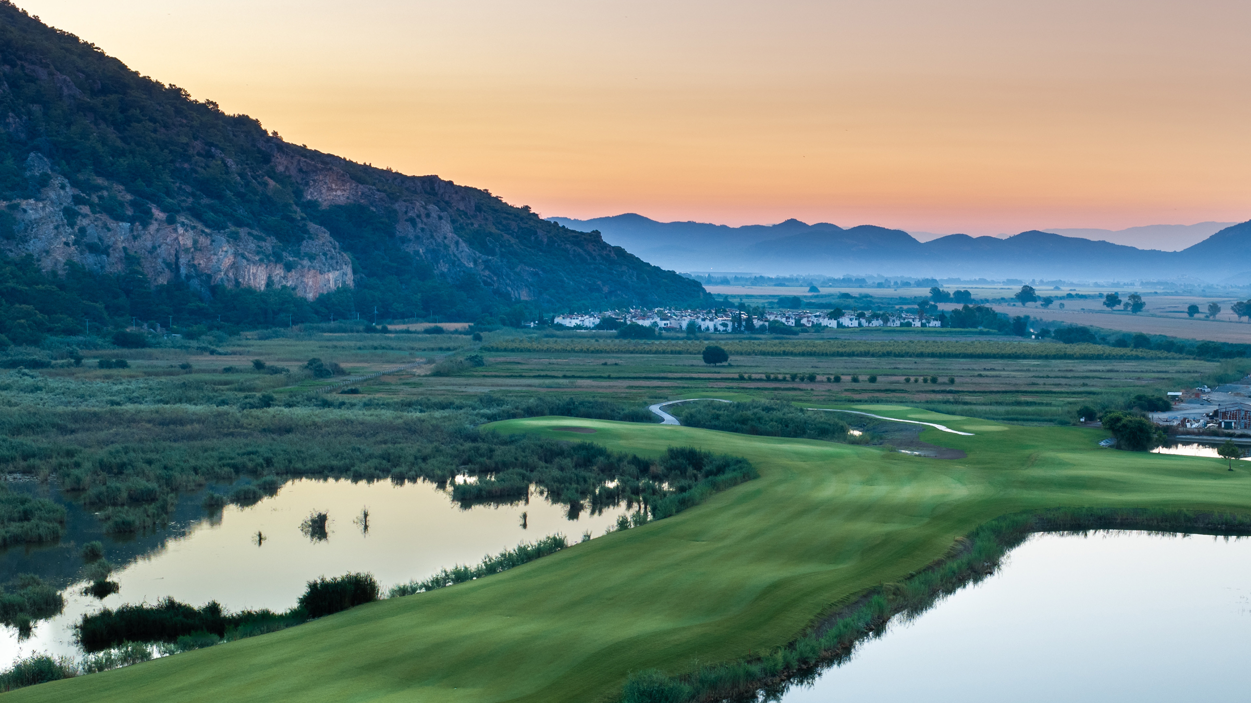 A hole at the Hilton Dalaman with water right and mountains in the background