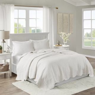 A white bed in a white bedroom