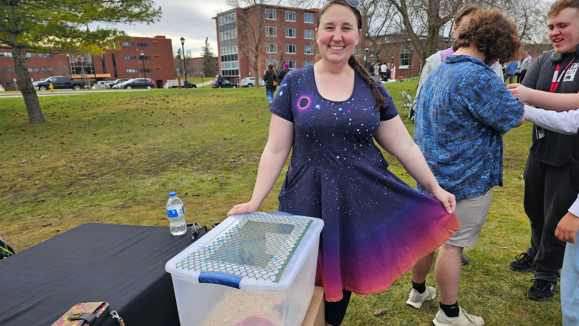 La profesora de biología de SUNY Potsdam, Sarah Sirsat, muestra un vestido de eclipse solar mientras muestra cómo reaccionan las codornices y otros animales al vestido de eclipse solar total el 8 de abril de 2024.