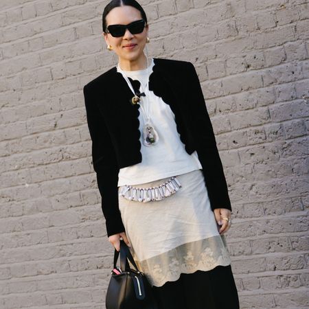 Linda Cui Zhang wearing a black jacket, white tee, and lace skirt