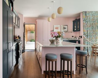 pink kitchen with bar stools and floral curtains