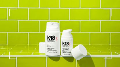 A selection of K18 hair products pictured in a lime green tiled bathroom for this k18 review