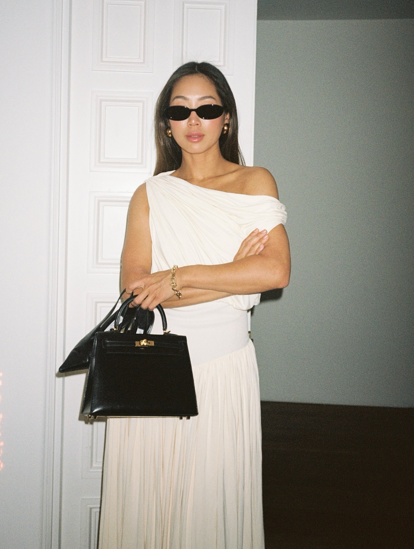 Aimee Song wearing a white dress and black leather bag