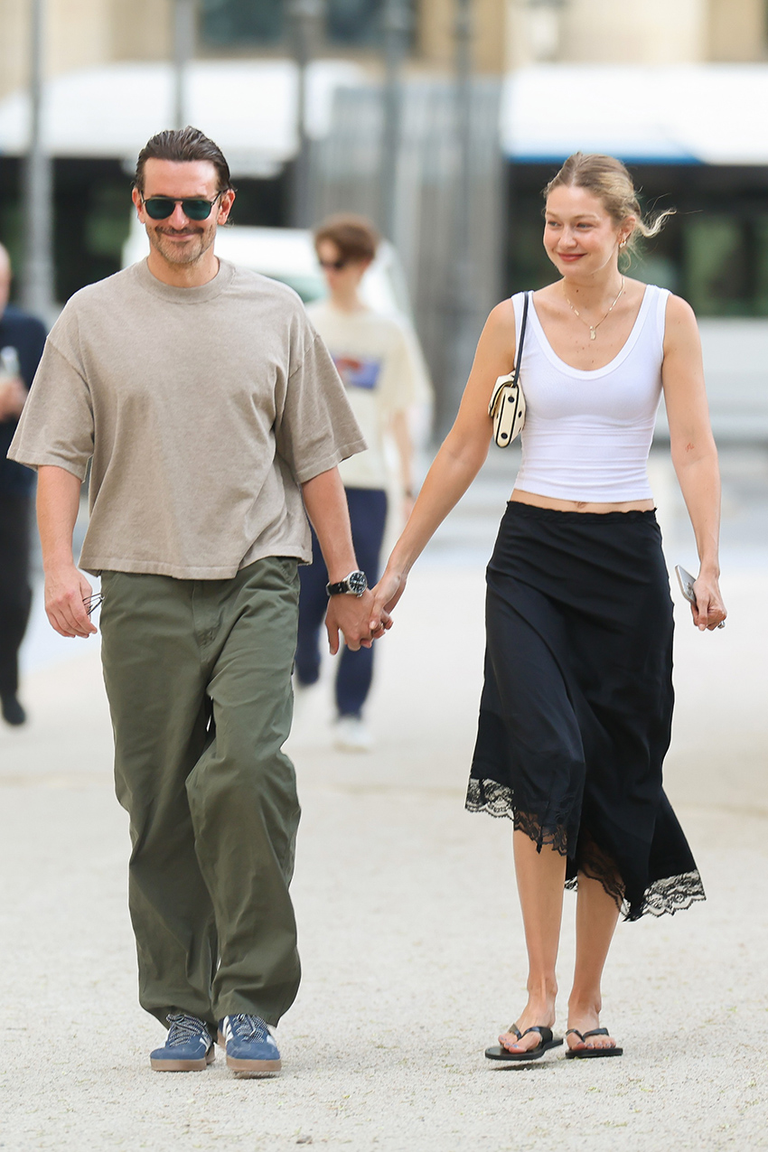 Gigi Hadid walking with Bradley Cooper in Paris. Gigi wore a white tank top with a black lace-trimmed midi skirt and black leather flip-flops. She carried a polka-dot Valentino Garavani DeVain bag
