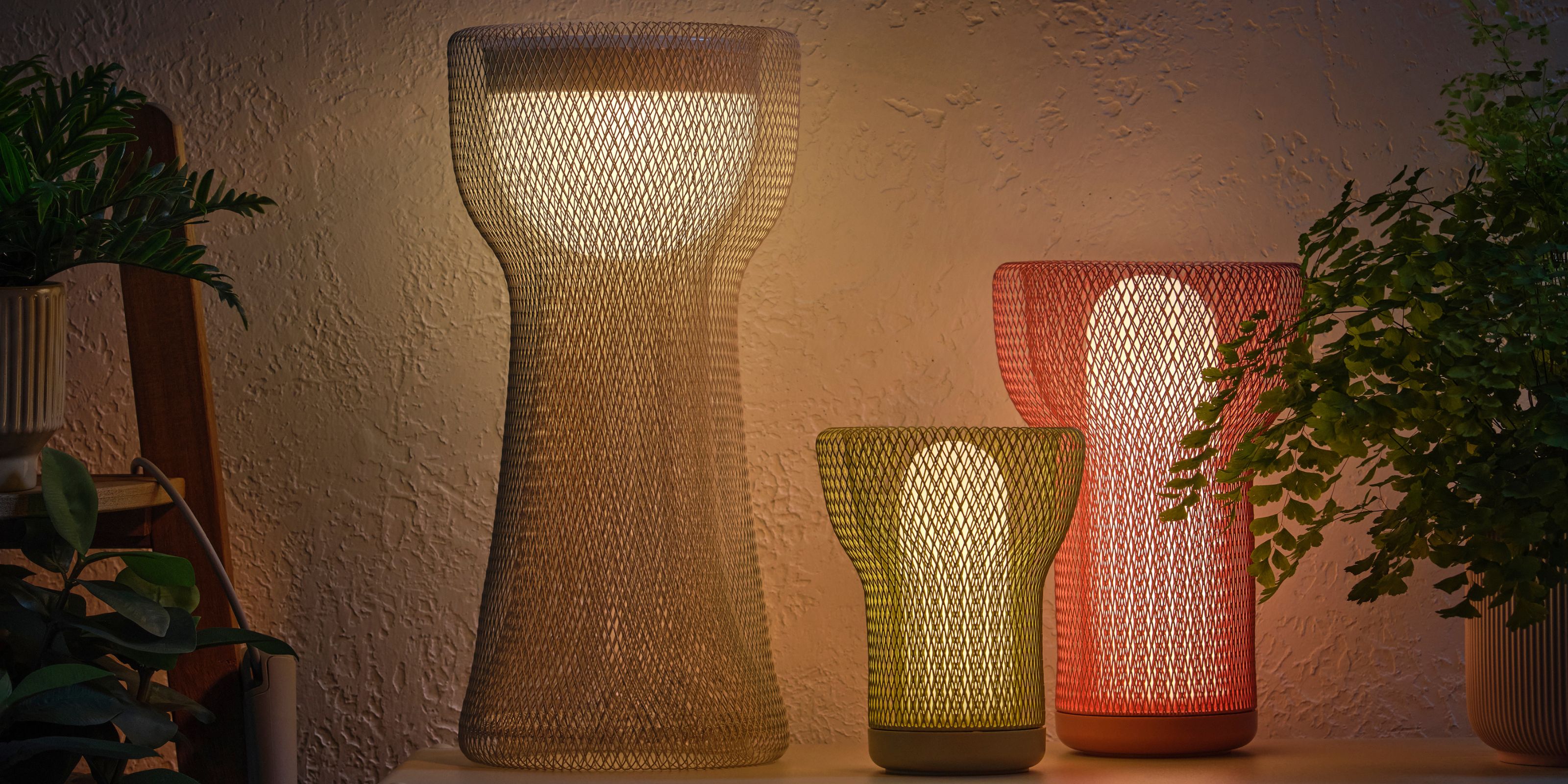 IKEA's mesh solar lamps against a white wall with plants
