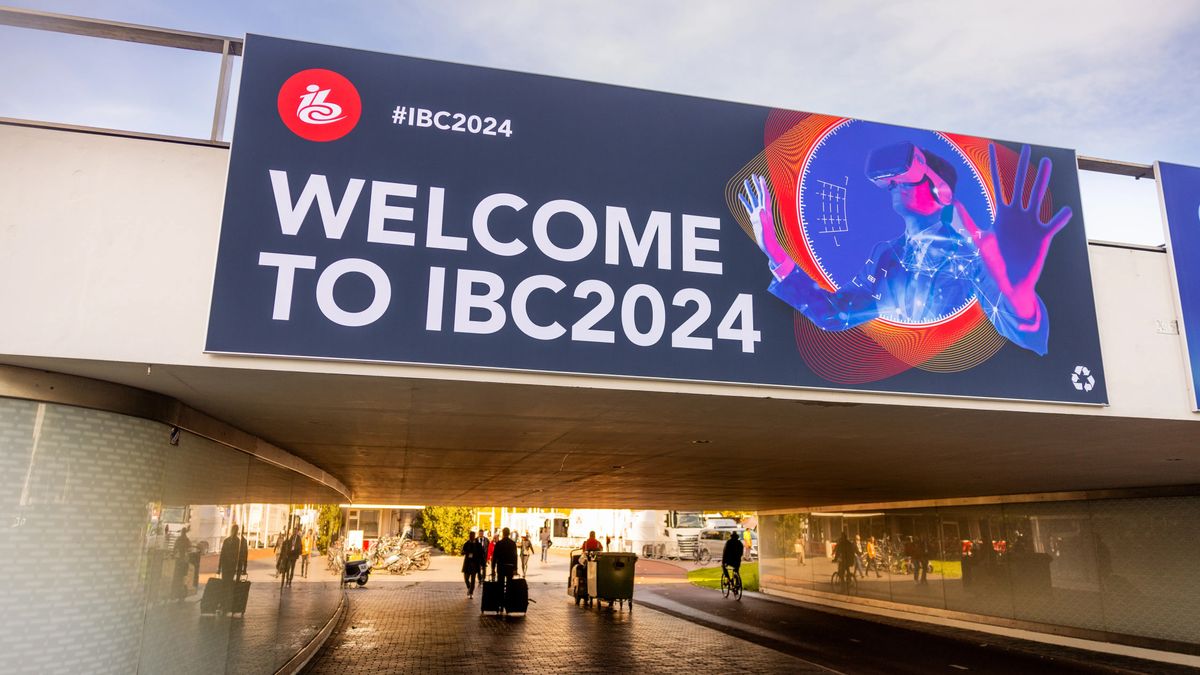 A large sign reading &quot;Welcome to IBC 2024&quot; above an underpass, with pedestrians walking beneath