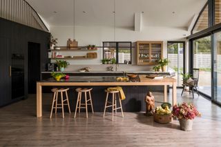 a black and wood kitchen in a modern architectural space