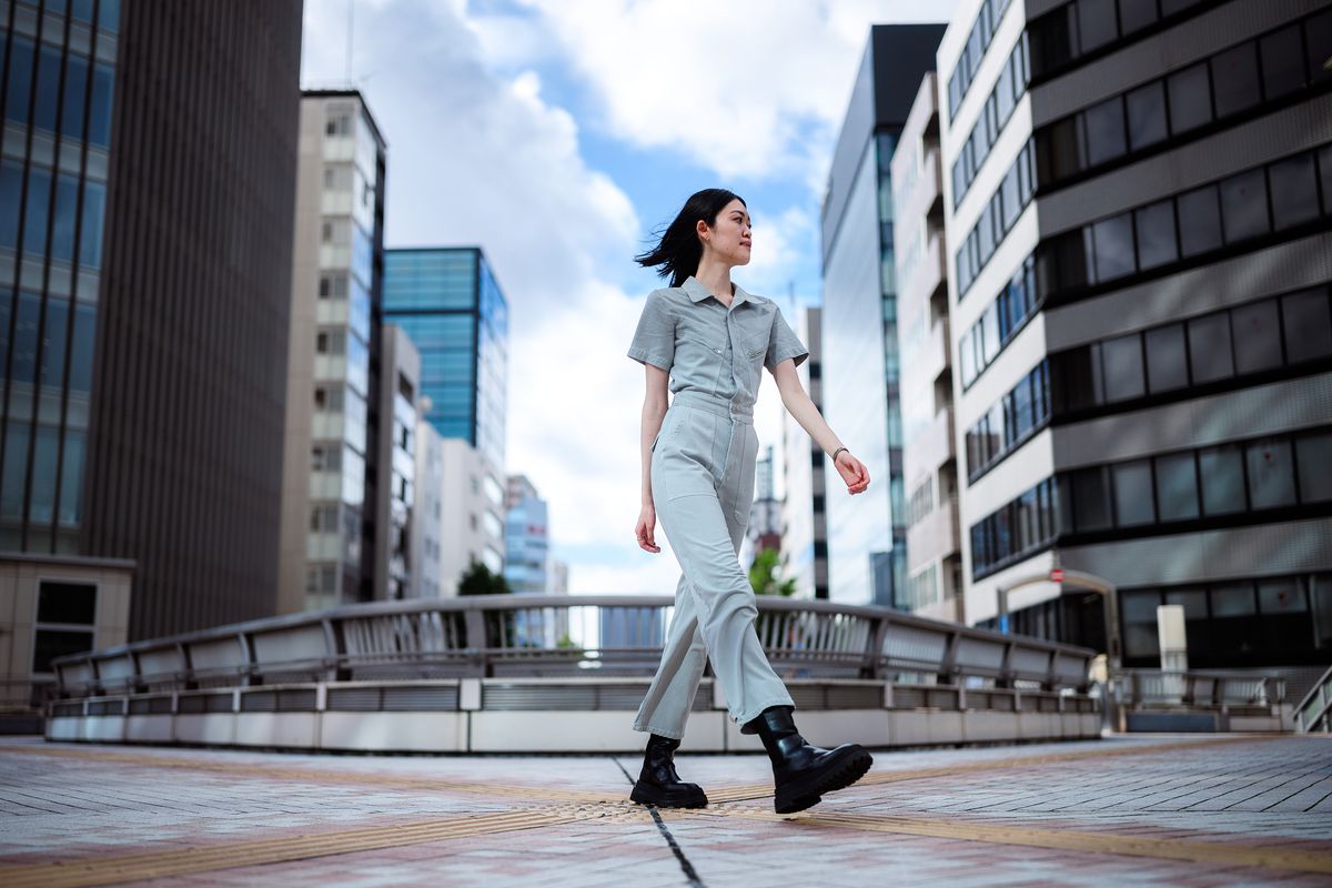 Sample image taken with a Nikon Z 35mm f/1.2 S lens showing a woman walking through a street scene