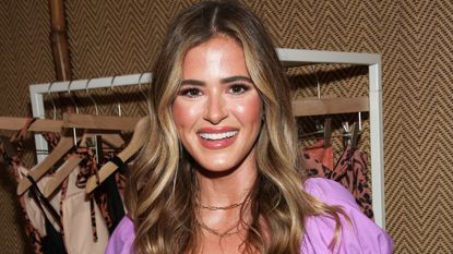 jojo fletcher wearing a purple dress in front of a rack of clothing