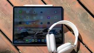 An image of an ipad on a wooden surface with headphones