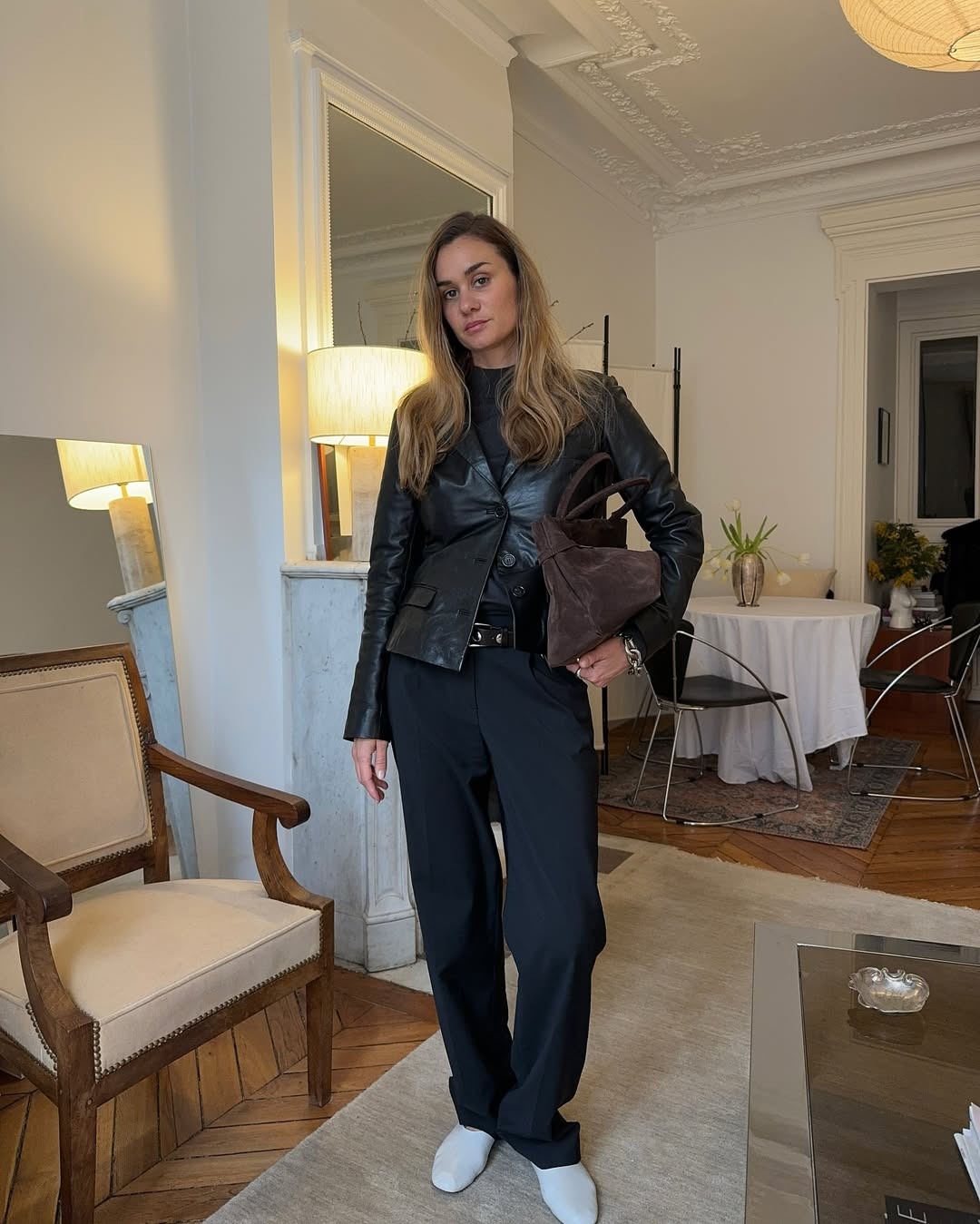 Parisian fashion icon Anne-Laure Mais sports a lived in all-black lived-in look. One button done on her leather blazer, clutching a brown suede tote, she is my style inspiration for an effortlessly chic fall.