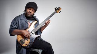 Victor Wooten posing against a grey background