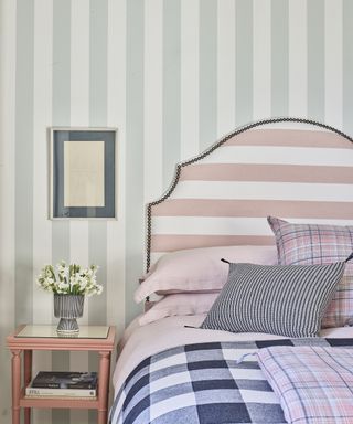 decorating with stripes in the bedroom using wallpaper and an upholstered headboard