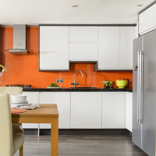 kitchen room with orange wall and white kitchen cabinets