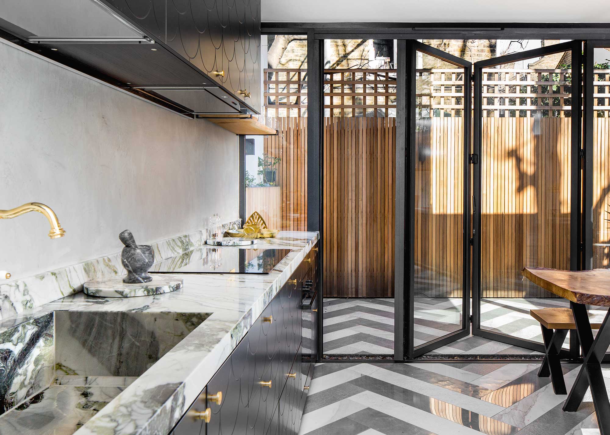 kitchen with marble worktops and black and white zigzag flooring and bifold doors