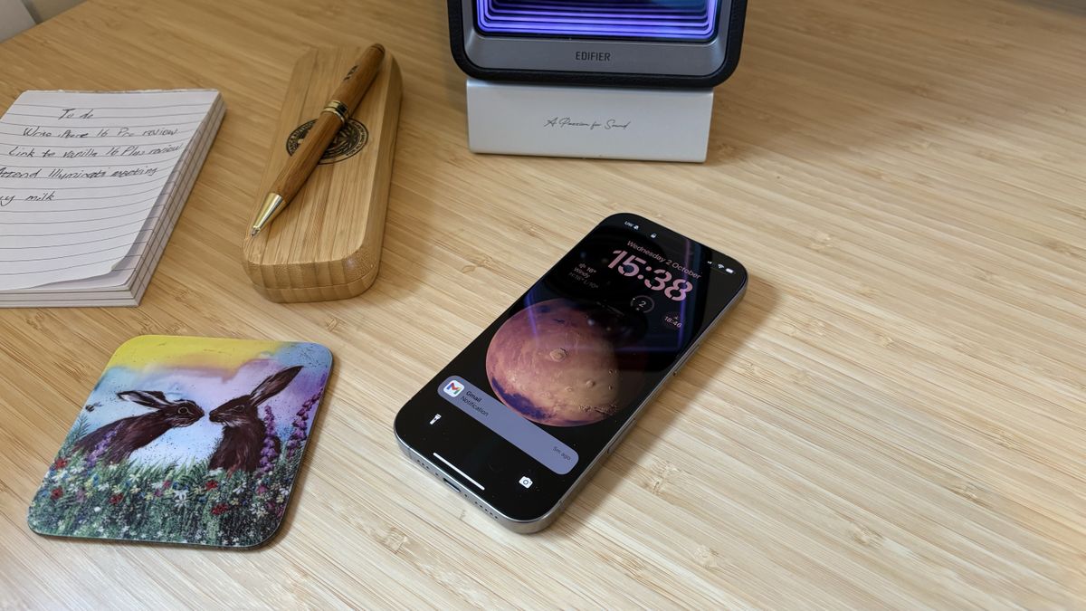 An iPhone 16 Pro on a wooden desk