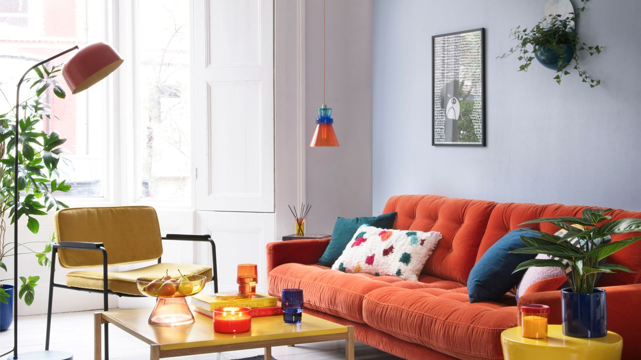 White dining table with orange cups and terrazzo plates