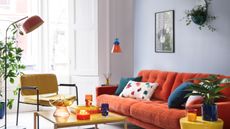 White dining table with orange cups and terrazzo plates