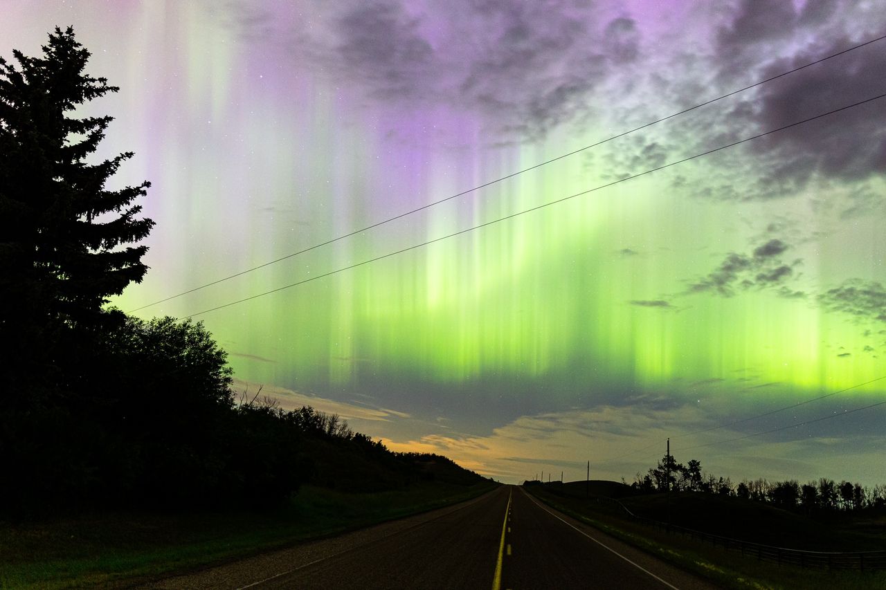 northern lights appearing as huge curtains of green light rippling along the sky.