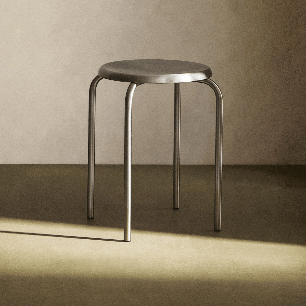 A rotating gif showing a brushed stainless steel stool.
