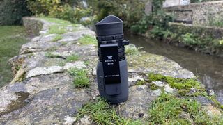 The Vortex Solo R/T 8x36 monocular stood on its end on a stone wall.