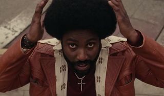 John David Washington as Ron Stalworth adjusting his afro in BlackKklansman