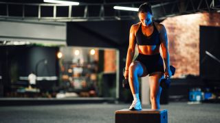 a woman doing a dumbbell step up exercise
