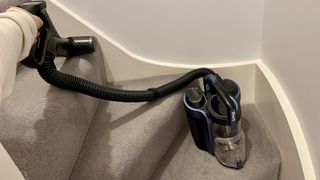 The Shark Anti Hair Wrap Cordless Upright Vacuum Cleaner with PowerFins, Powered Lift-Away & TruePet ICZ300UKT being used as a portable vacuum to clean stairs