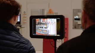 Dos personas viendo un monitor de video.