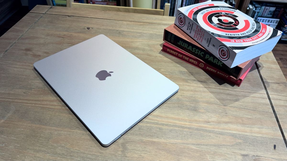 The 2024 MacBook Air M3 on a wooden table in front of a bookshelf.