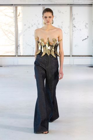 Woman on Area runway in top made from gold bananas and jeans