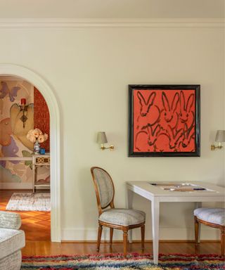 spring decorated home with a small games or craft table with a large bunny rabbit abstract piece of art hung above