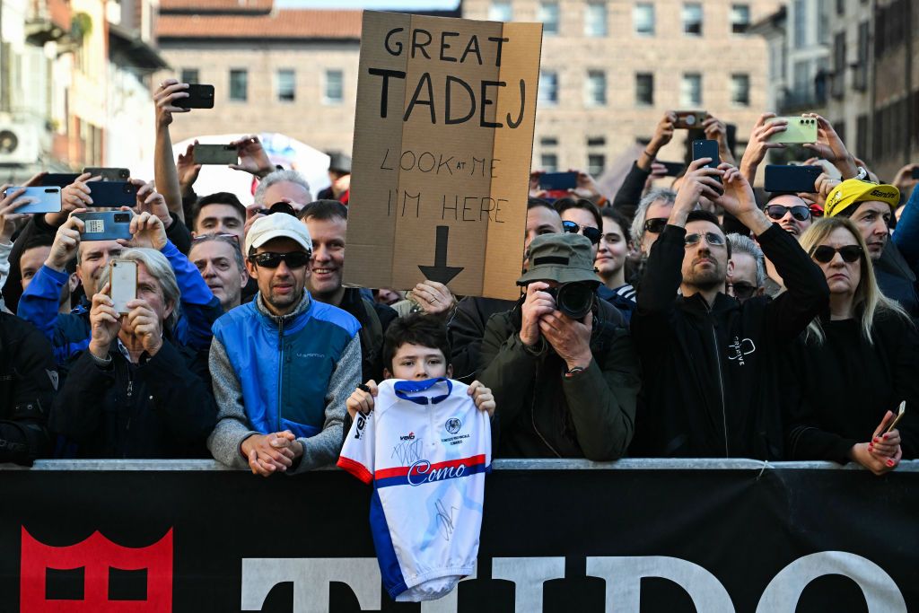 A supporter of UAE Team Emirates' Slovenian rider Tadej Pogacar (unseen) holds a banner during the 115th Milan-SanRemo one-day classic cycling race, in Pavia, on March 16, 2024. (Photo by Marco BERTORELLO / AFP)