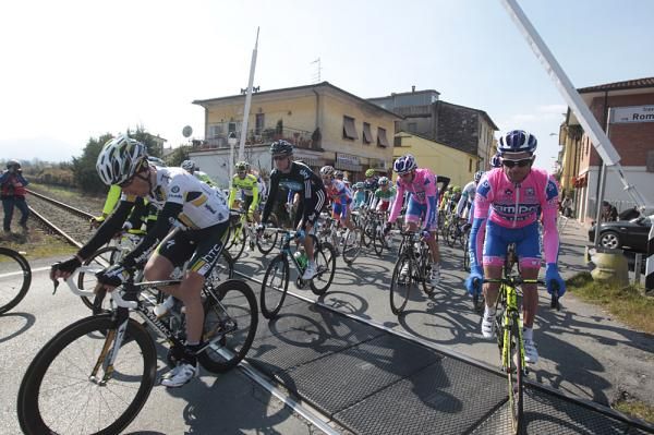 The bunch gets going again after being stopped by a train.