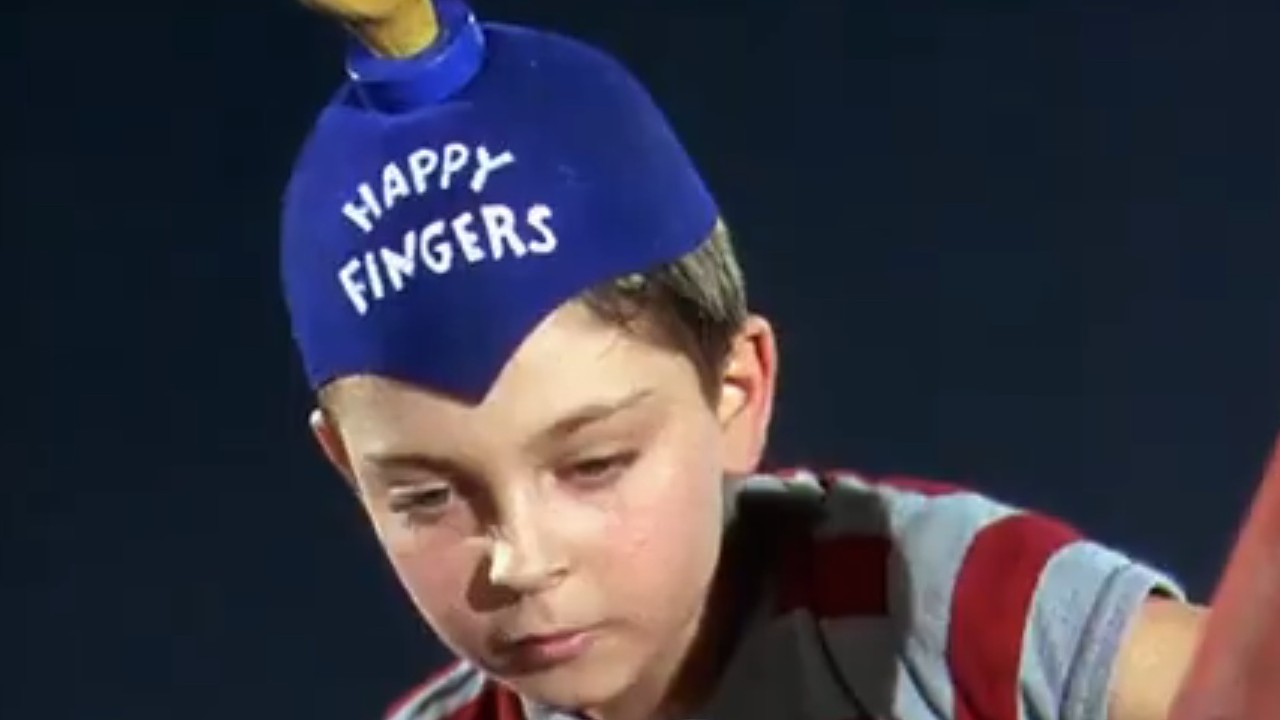 『ドクターTの5000本の指』で青いハッピーフィンガーズの帽子をかぶったトミー・レティグ