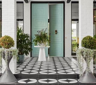 A turquoise door and black& white flooring