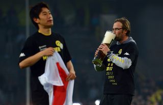 Jurgen Klopp drinks beer on the pitch after Borussia Dortmund's Bundesliga title win in April 2012.