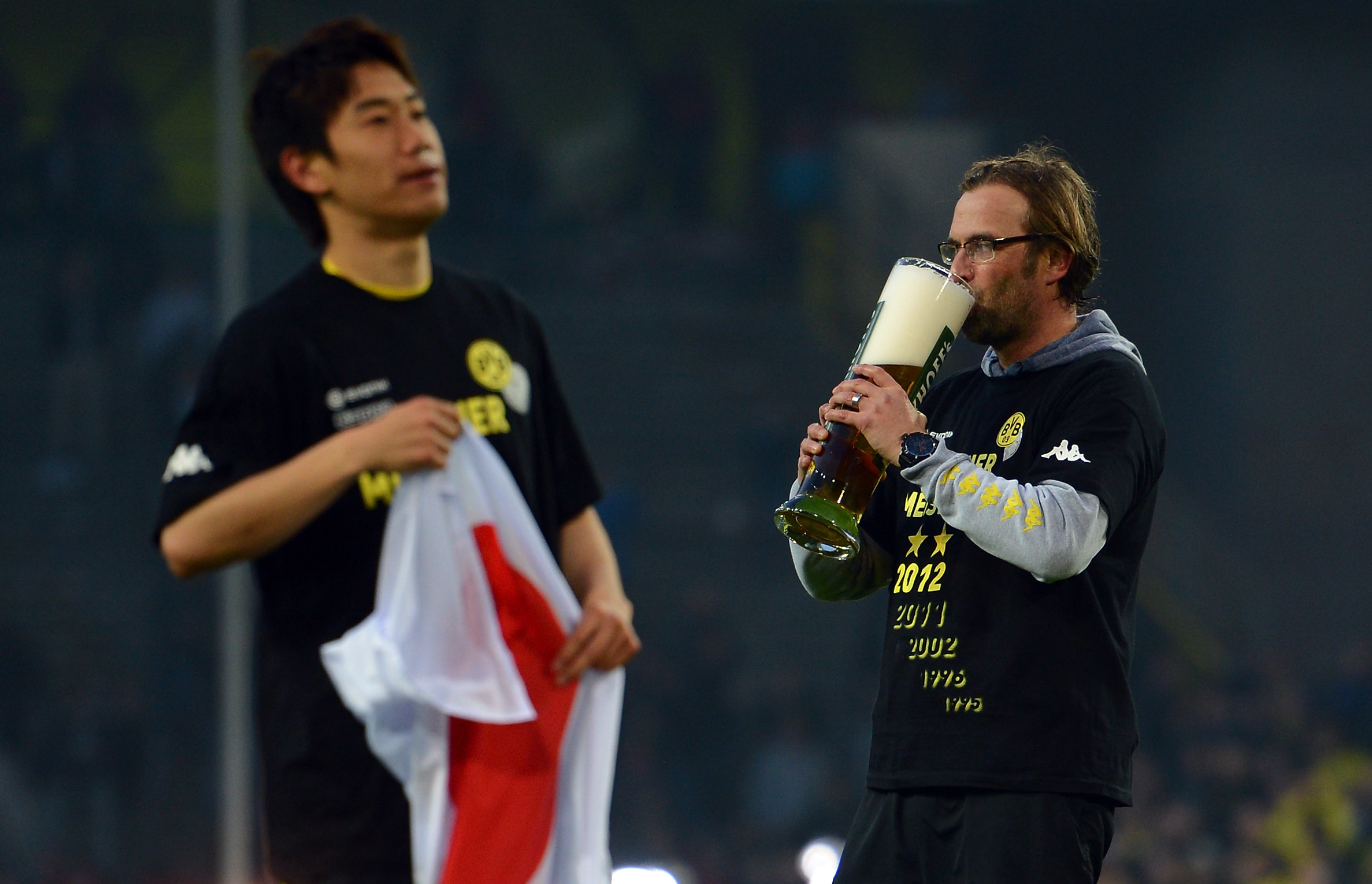 Jurgen Klopp drinks beer on the pitch after Borussia Dortmund's Bundesliga title win in April 2012.